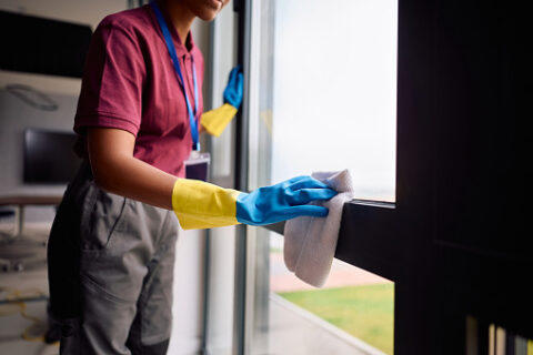 Office Window Cleaning Service Cleaner wiping down an office window during a commercial window cleaning service