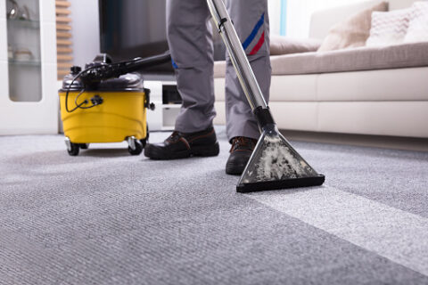 Carpet cleaner using a professional machine to clean an office reception carpet